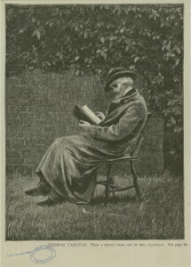 Carlyle in a coat, sitting in a chair, reading a novel our in nature.